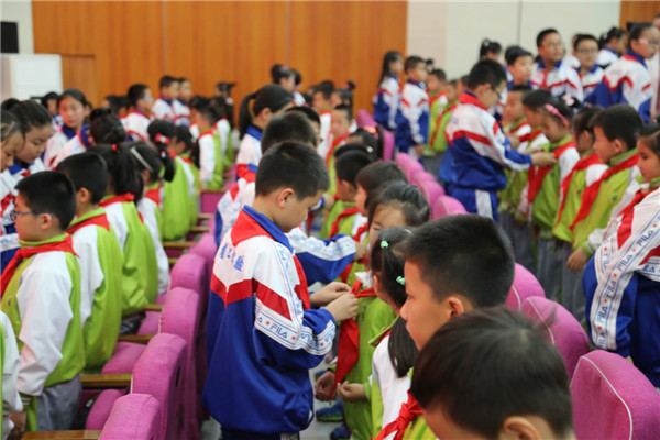 五年级的优秀少先队员代表为新少先队员佩戴红领巾.jpg
